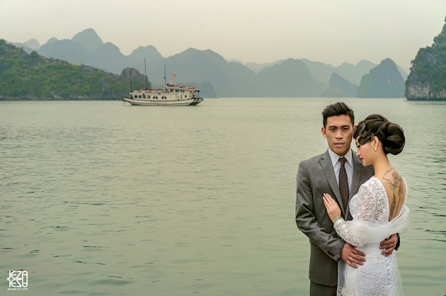 Bride and groom Ha Long Bay, Vietnam, wearing traditional western wedding outfits (suit & wedding gown)