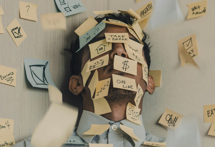 Man covered in post-its - Photo by Luis Villasmil on Unsplash (https://unsplash.com/photos/people-sitting-on-chair-with-brown-wooden-table-mlVbMbxfWI4)