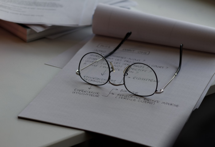 Glasses resting on paper pad with technical notes