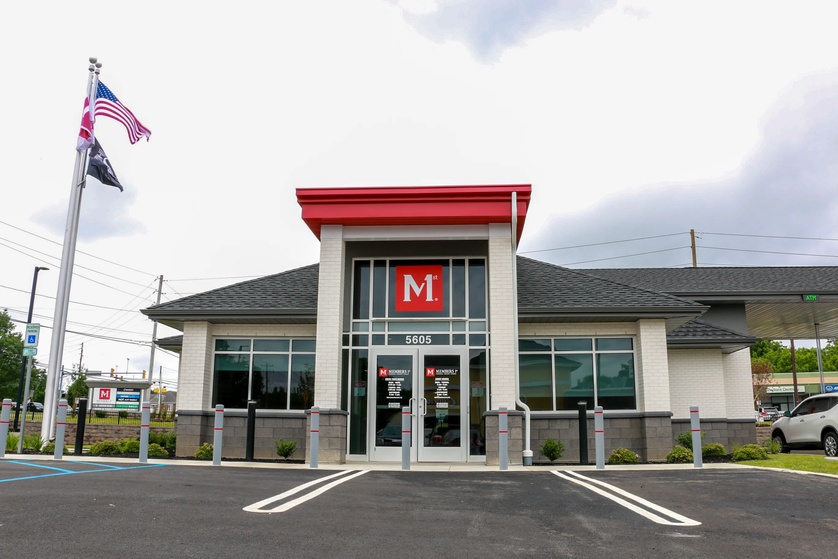 Trexlertown Members 1st Federal Credit Union branch with red roof and red M logo above entrance, American flag on pole, parking lot in front.