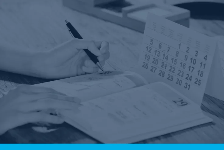 person_writing_in_planner_with_calendar