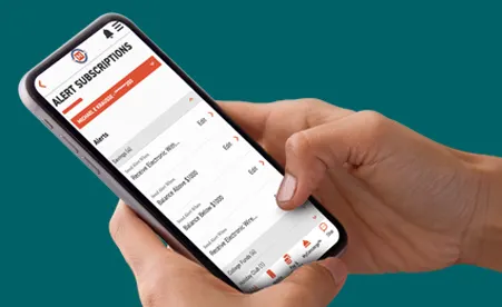 Hand holding smartphone displaying account alerts in digital banking app on teal background