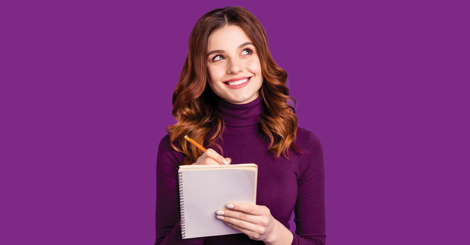 Woman in purple turtleneck holding notebook and pencil, smiling and looking up thoughtfully against purple background.