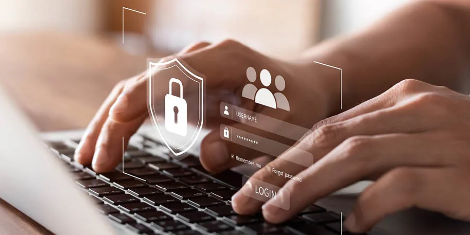 Hands typing on laptop keyboard with digital security login interface overlay showing lock shield and user icons