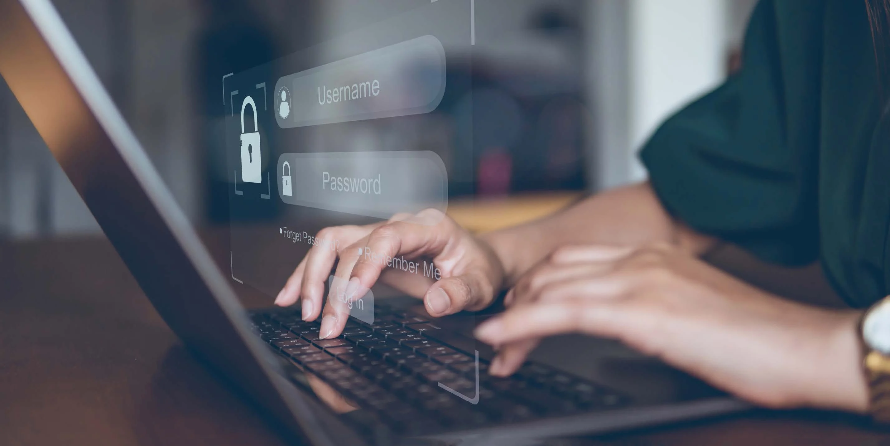 Hands typing on laptop keyboard with translucent login screen overlay showing username and password fields with lock icons.