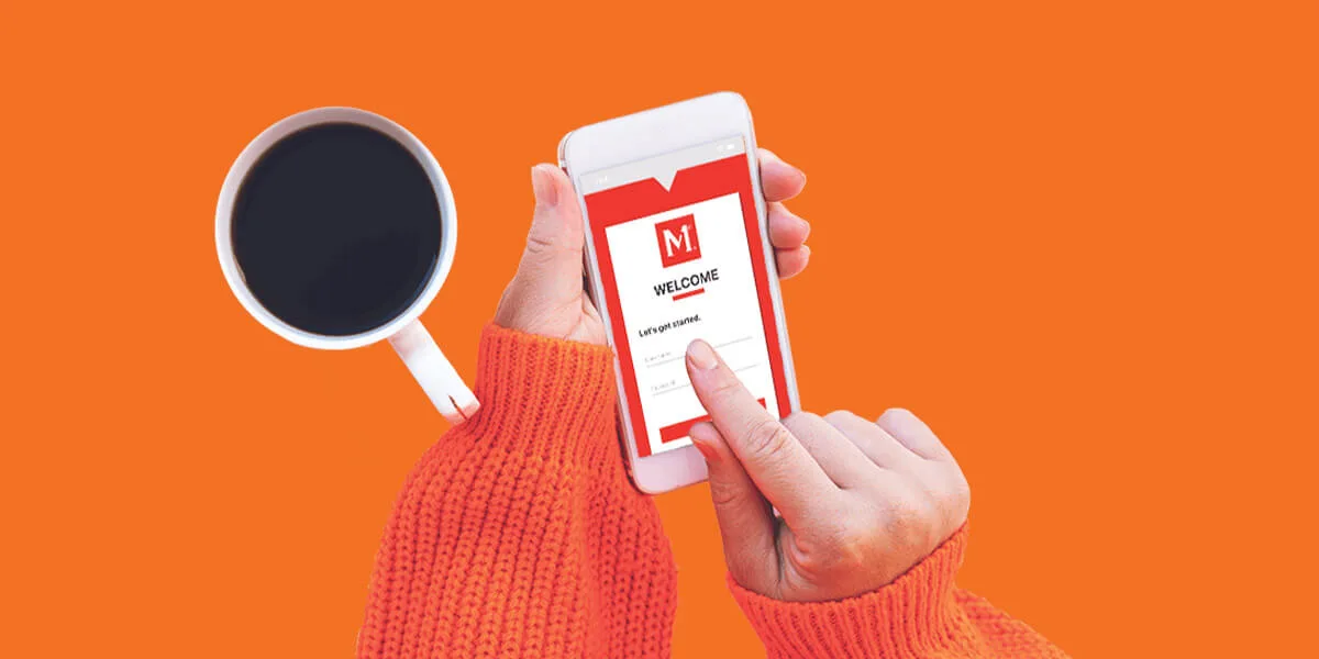 Person in orange sweater holding coffee cup and smartphone displaying welcome screen with red and white app interface