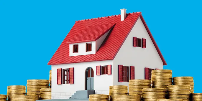 White house model with red roof and shutters surrounded by stacks of gold coins on blue background