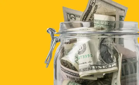Jar of cash on yellow background