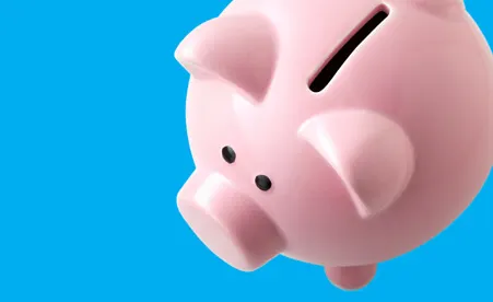 Pink piggy bank on blue background