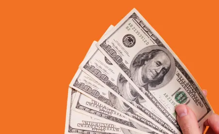 Spread cash on orange background