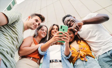 Group of friends looking at one person's phone