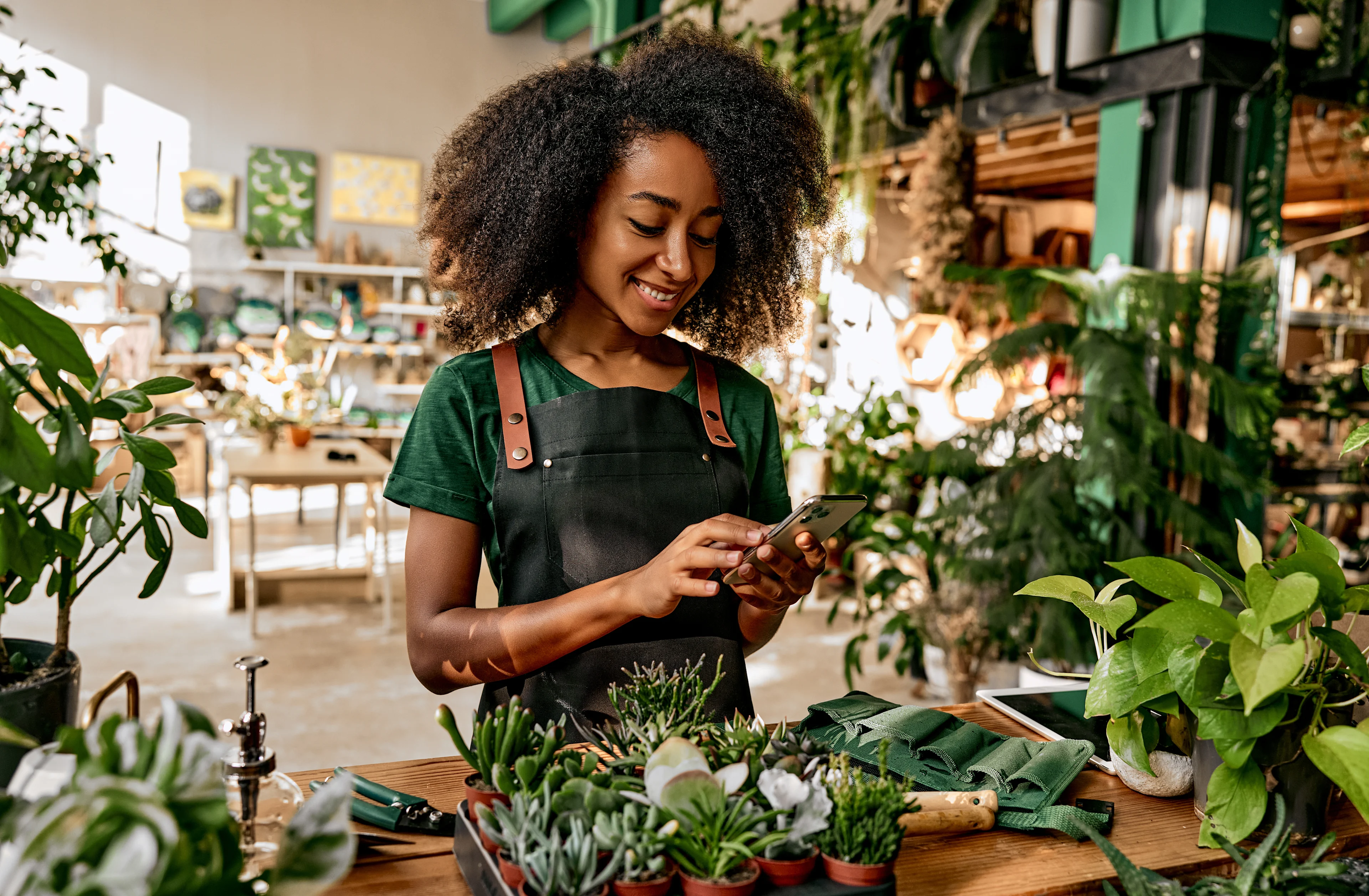 Women checking her phone in greenhouse