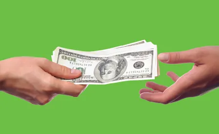 Hands exchanging cash money on green background