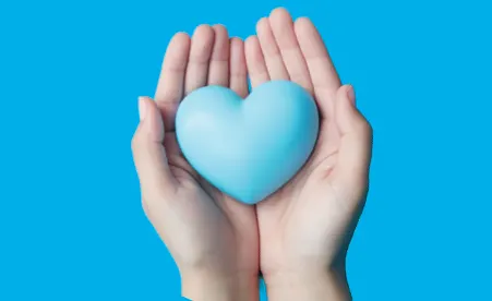 Hands holding heart shape on blue background