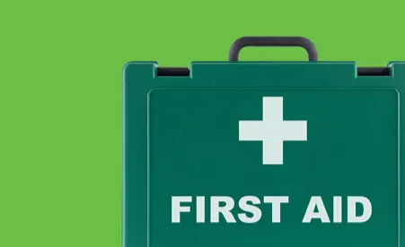 First aid kit on green background
