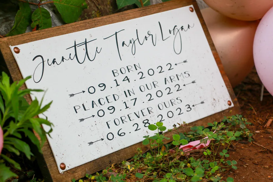 Memorial plaque on wood with name Juanette Taylor Lynn and dates: born 09.14.2022, placed in arms 09.17.2022, forever ours 06.28.2023.