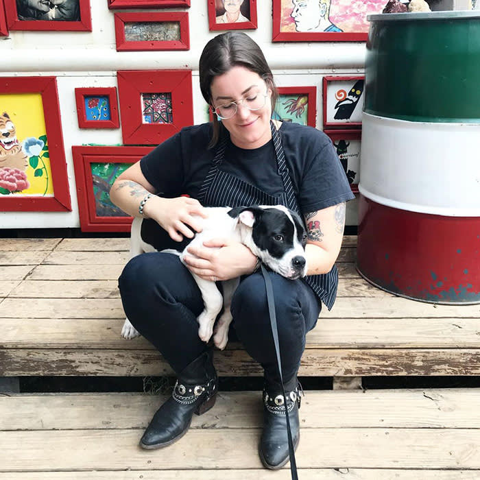 person holding black and white puppy
