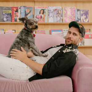 A man and his dog sitting on a couch posing for a picture. 