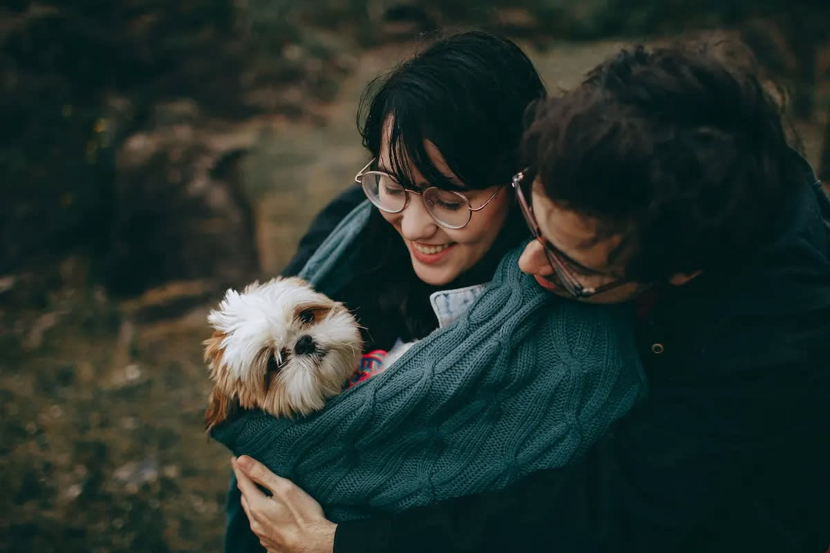 Two people holding a dog