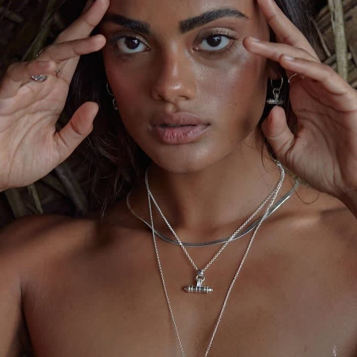 a close up picture of a woman wearing silver jewellery