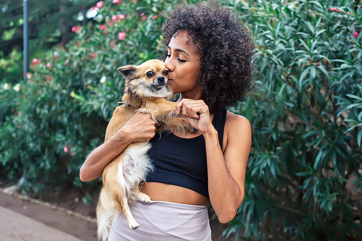 a woman cuddling her Chihuahua 
