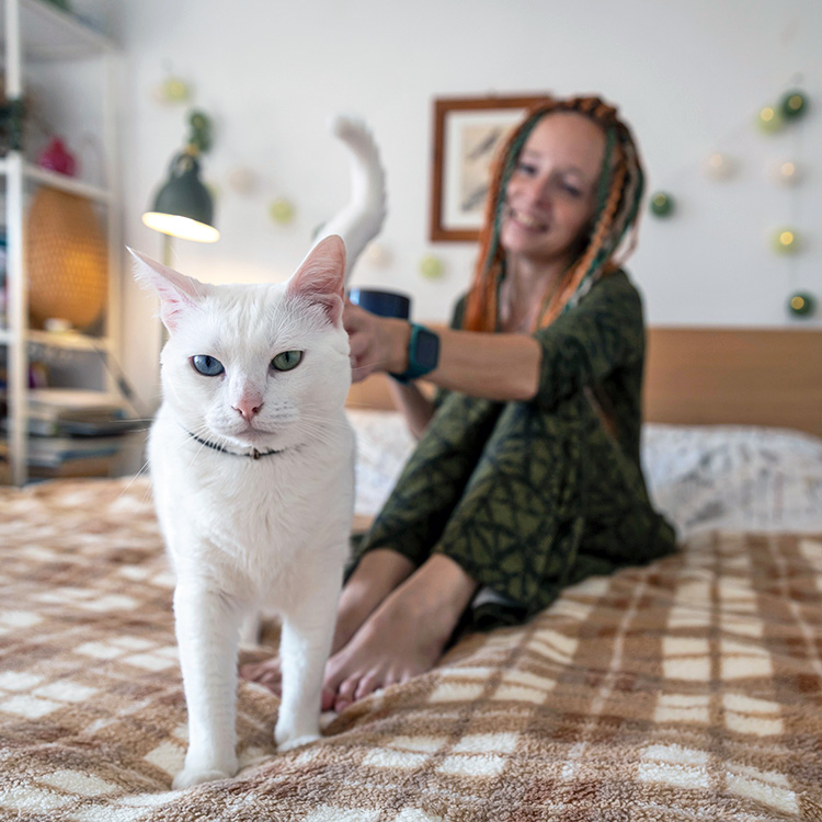 Woman petting her cat at home.