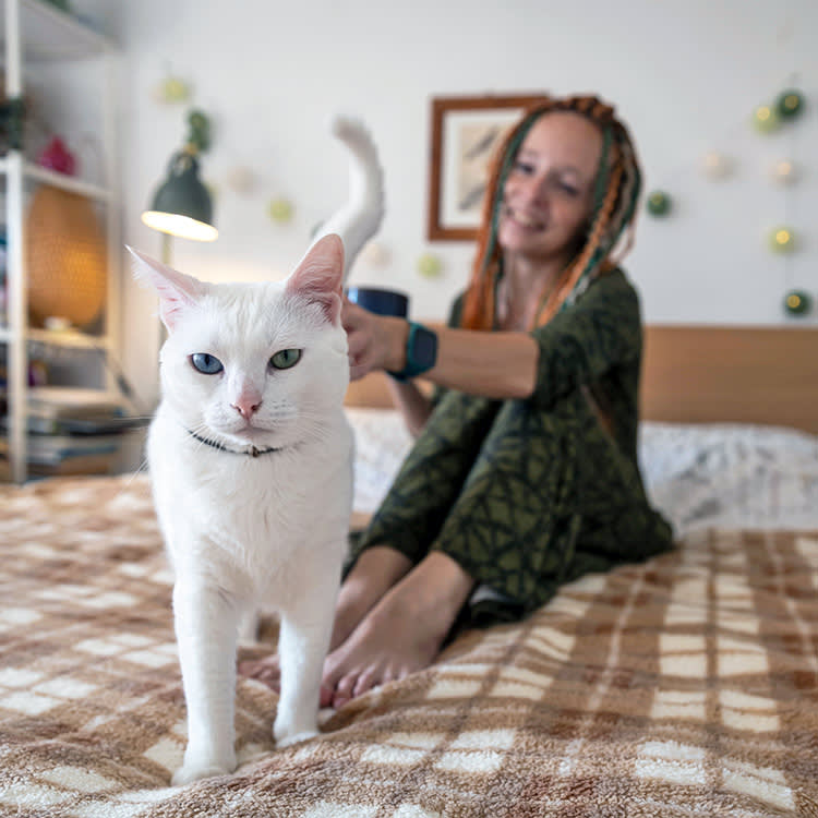 Woman petting her cat at home.