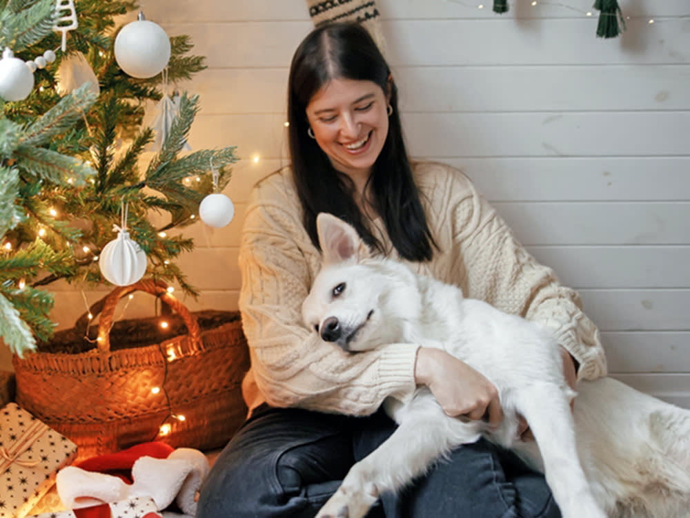 Woman snuggling her dog during Christmas time.