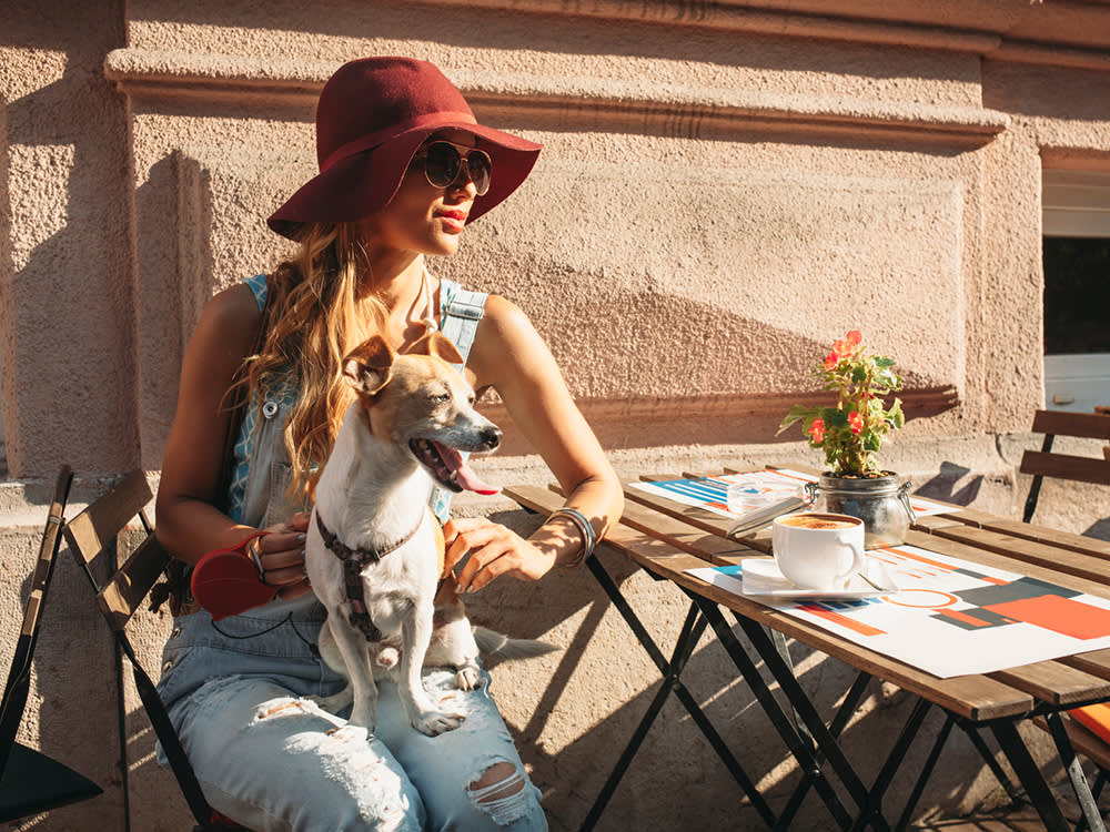 Woman sitting in a cafe with her dog.