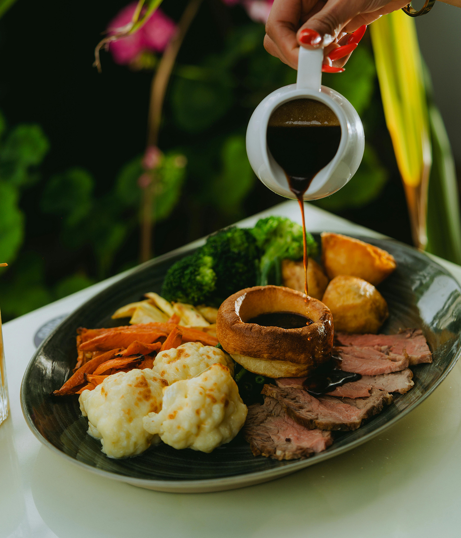 Pouring gravy on a roast dinner 