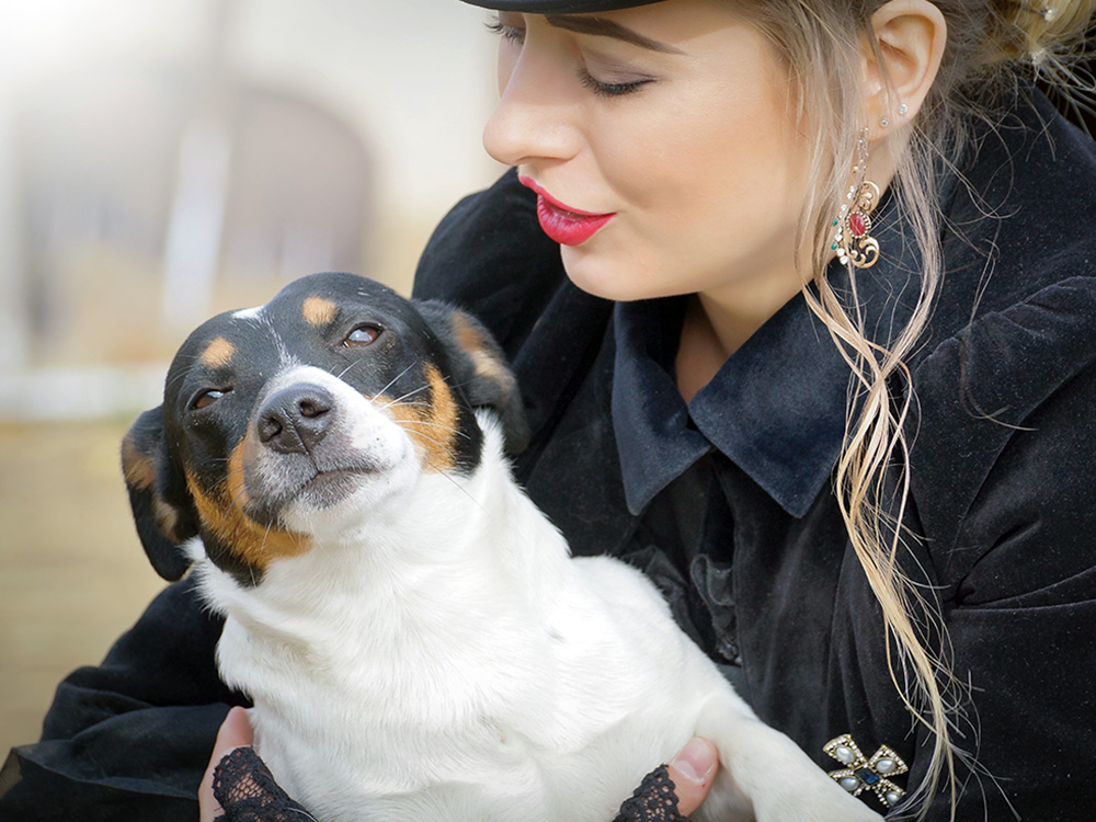 Dog pulling away from woman outside.