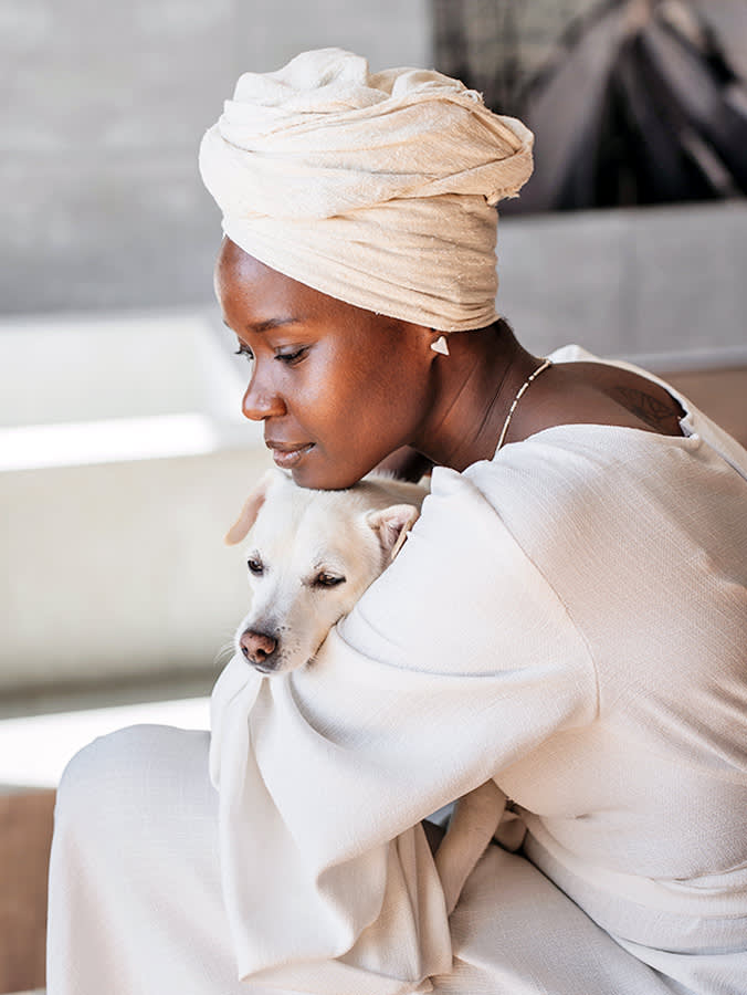 Woman holding her dog close to her outside.