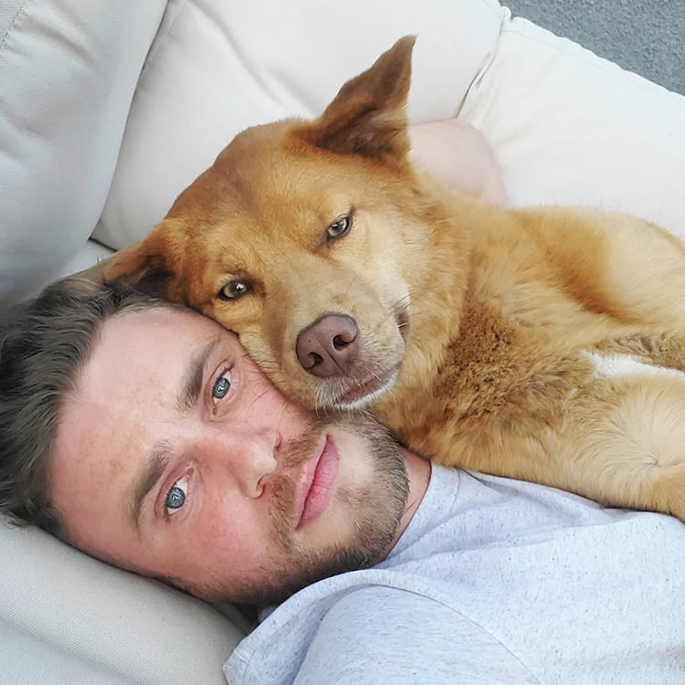 Gus Kenworthy cuddling on the couch with his dog Birdie