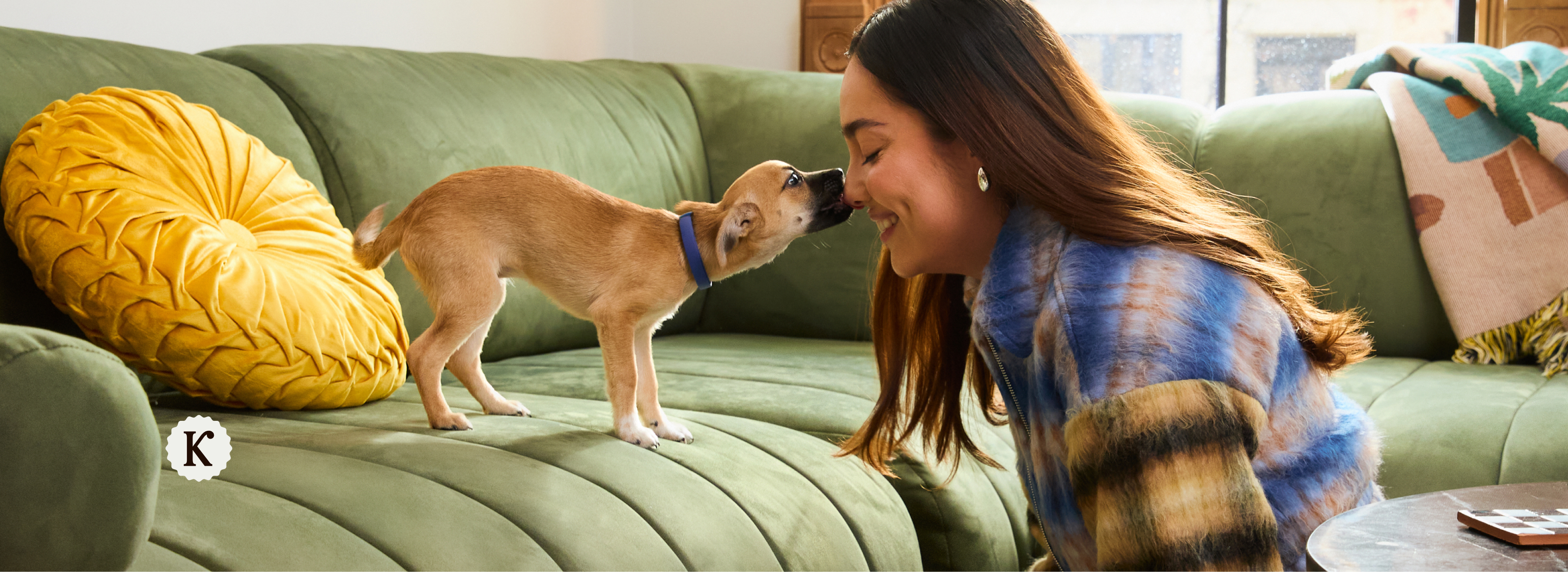 person smiling on a bed with a cat and dog