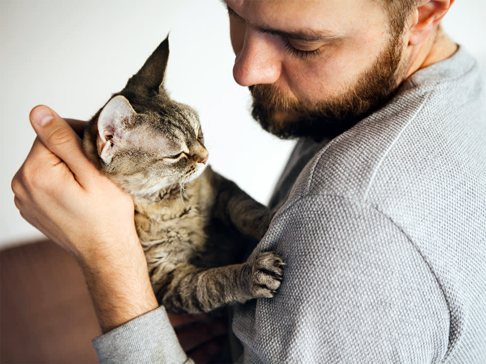 Man and cat looking at each other with affection. 
