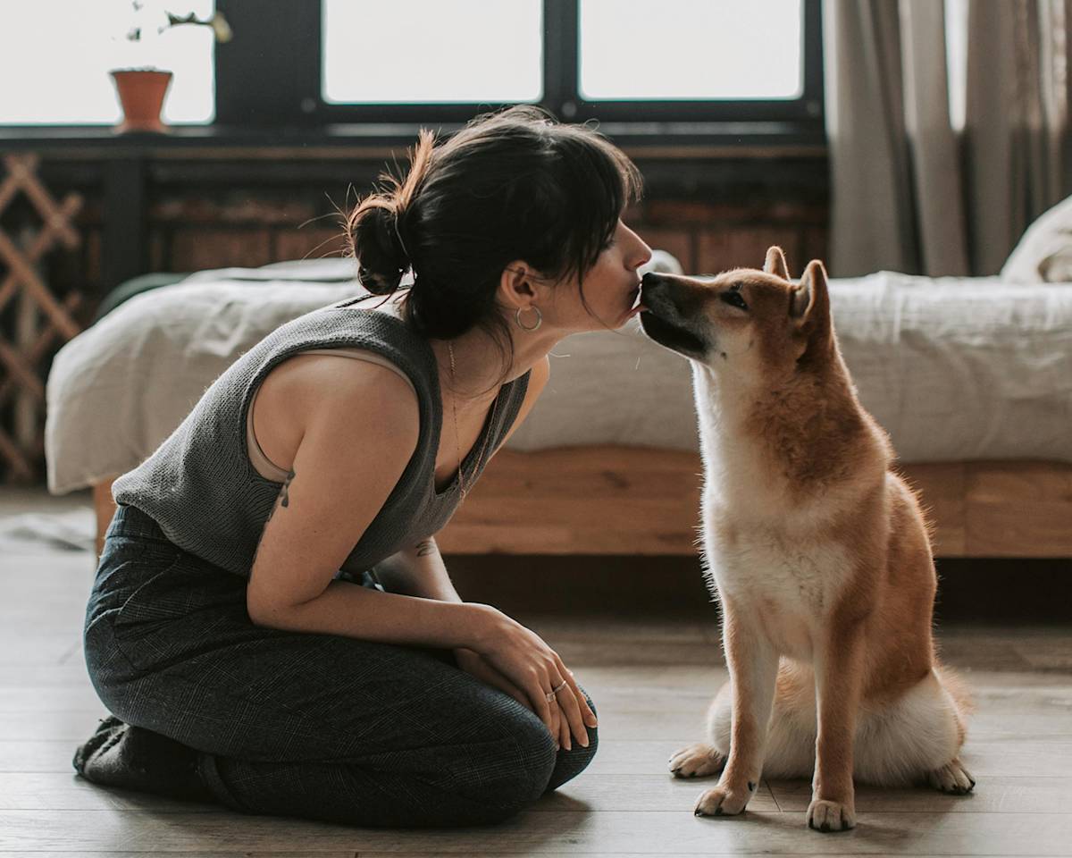 Woman Sitting on Wooden Floor with Her Dog