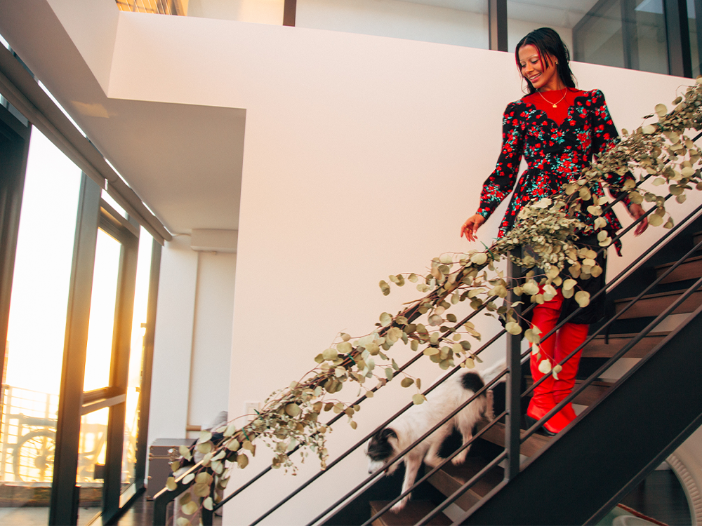 Sami Miró with her small rescue dog on a staircase 
