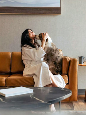 Woman snuggling her dog at home.