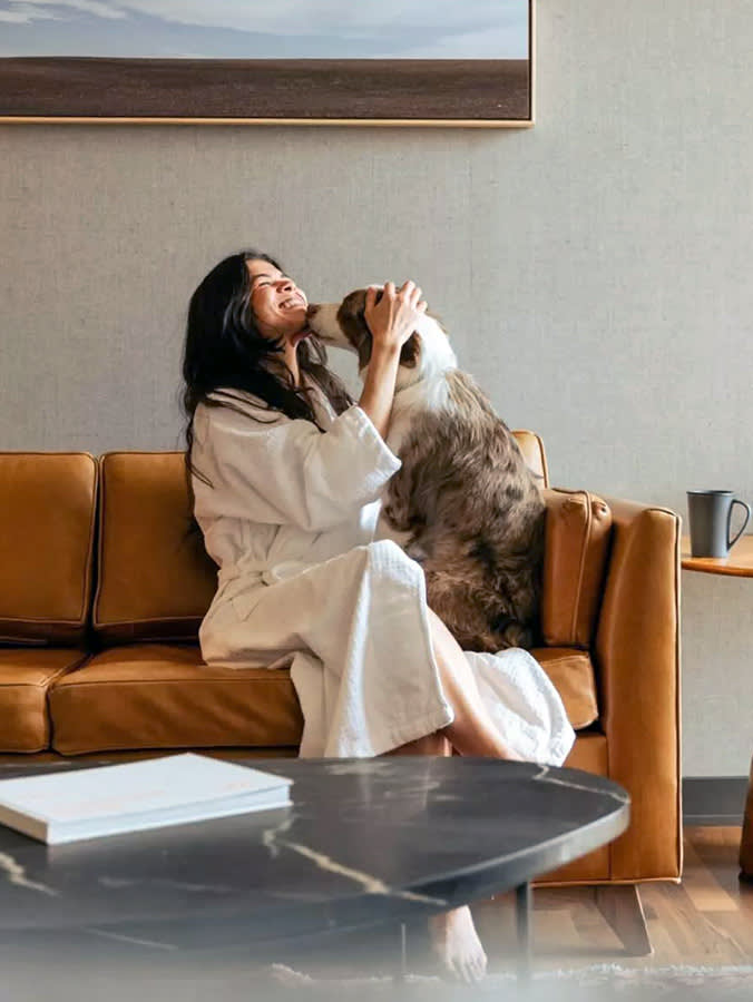 Woman snuggling her dog at home.