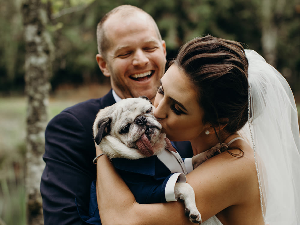 Happy Wedding Couple Holding Dog