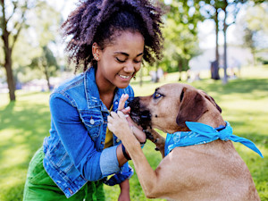 Woman training her dog outside.