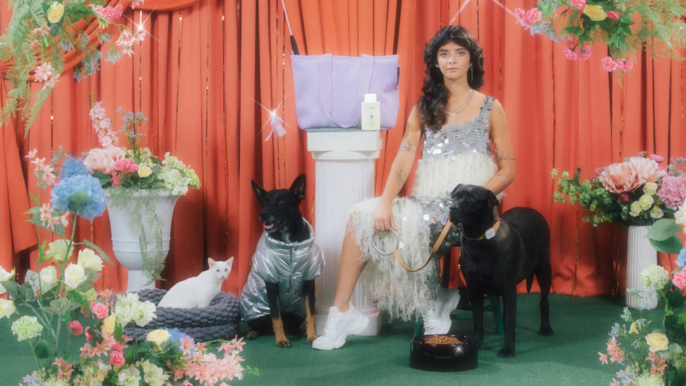 Woman sitting with two dogs in dream-like surrounding 