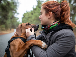 Redhaired woman holding her Rhodesian ridgeback dog