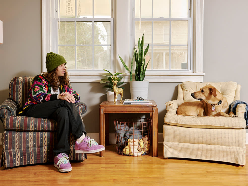 Briston Maroney and his dog on chairs looking at each other