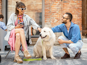 Friends outside with a dog on a leash.