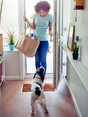 dog greeting a woman at the door