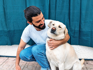 Man hugging his golden retriever dog.