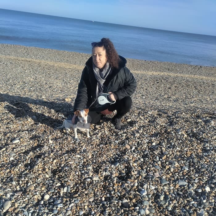 a woman and her dog on a beach
