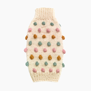 beige sweater with pink green and orange pom pom