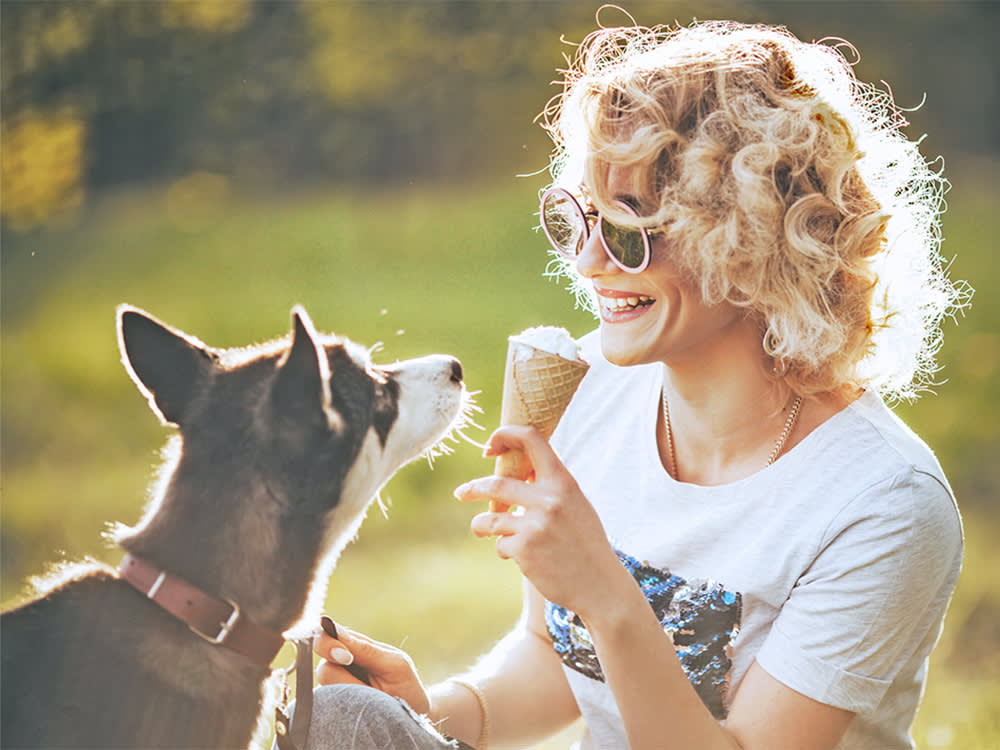 Woman sharing ice cream with her pet dog.